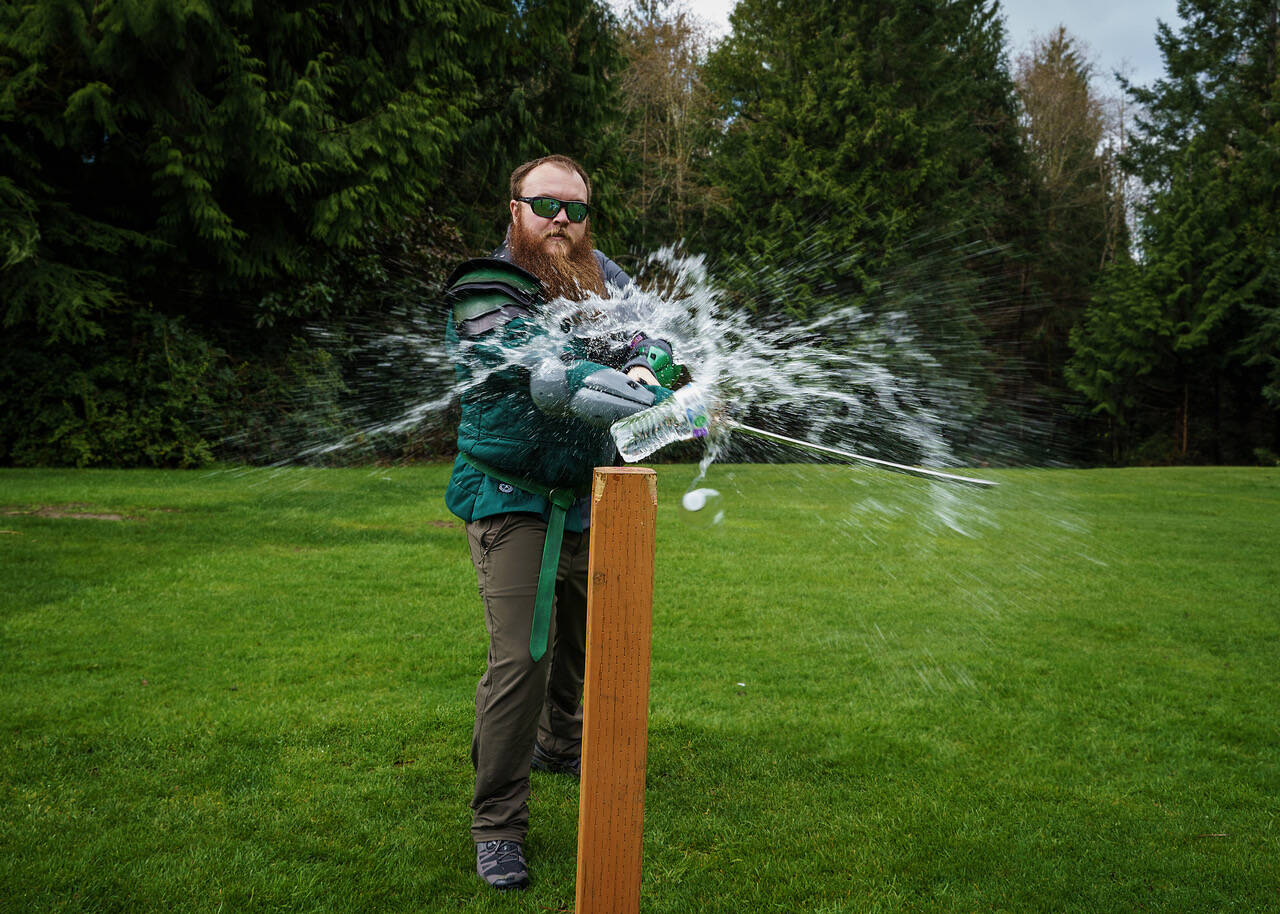 Jeremy Coleman of the Snohomish Dueling Society slashes a water bottle with his sword. (Photo by David Welton)