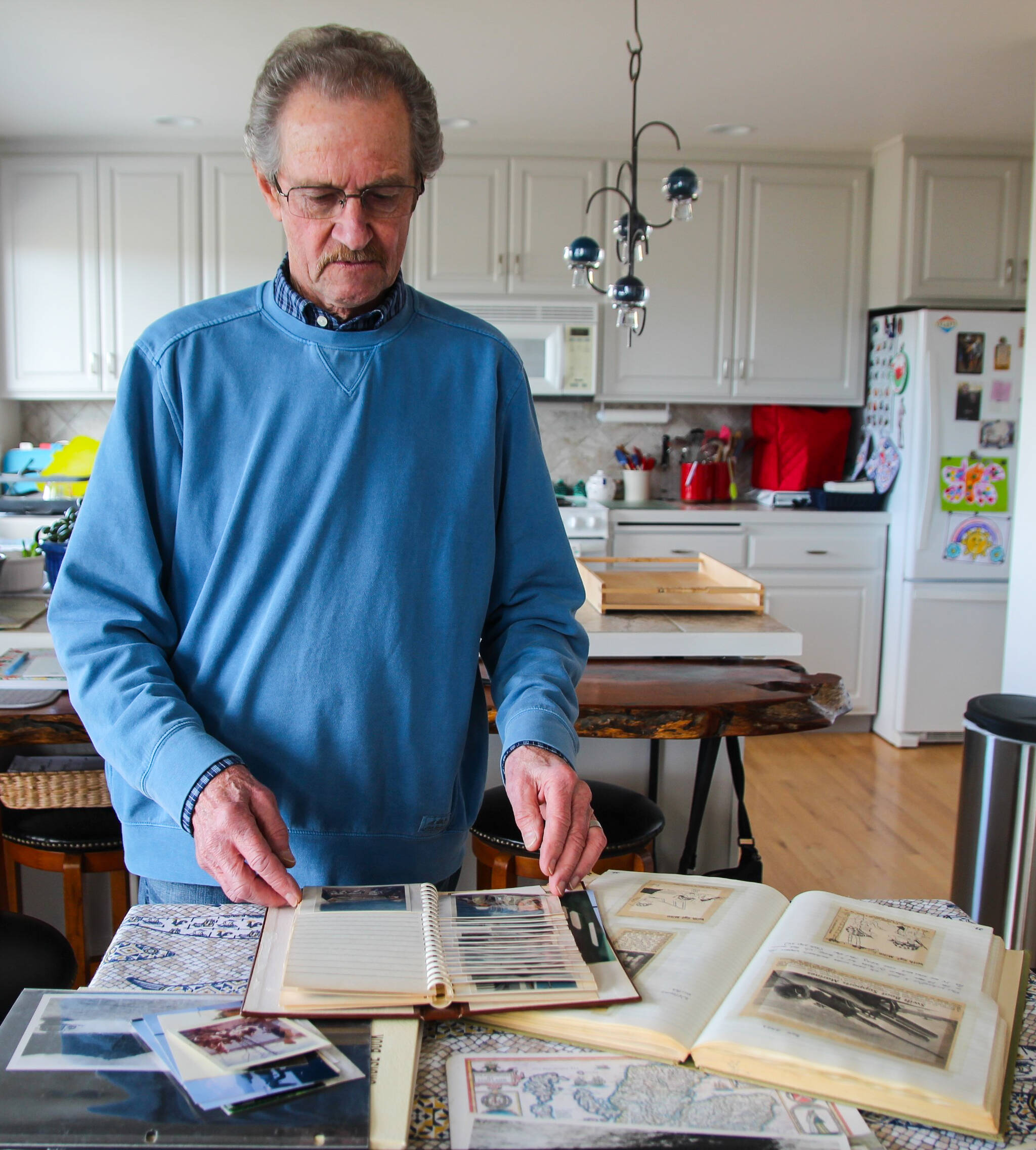 Donald Kaiser, a veteran, looks through photos from the Vietnam War. To this day, he keeps an extensive collection of photos, newspaper cut-outs and diary entries he collected and wrote while he was in charge of a crew of five men on board a swiftboat. (Photo by Luisa Loi)