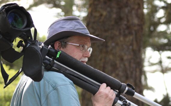 Steven Ellis carries his spotting scope through Ft. Ebey State Park. (Photo provided)