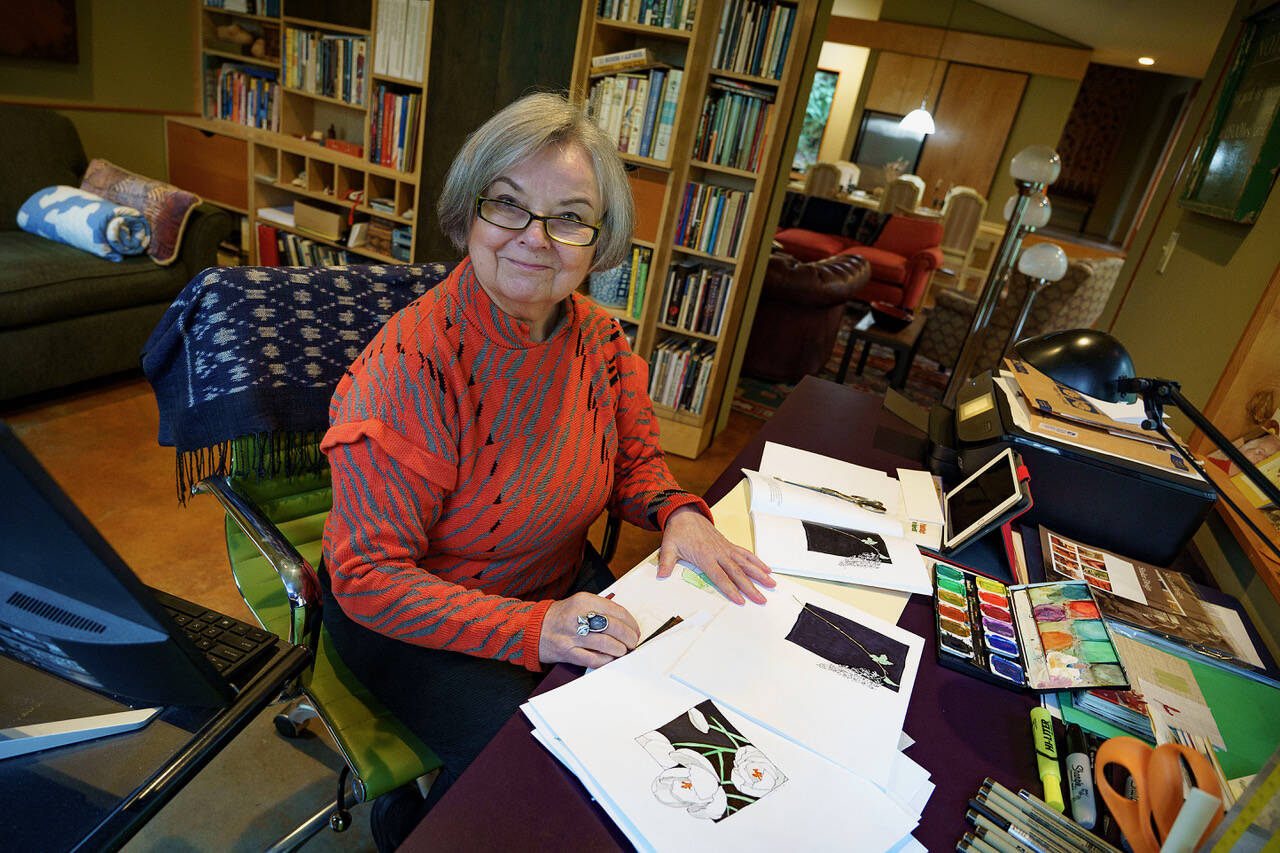 (Photo by David Welton)
Linda Beeman sorts through the stack of watercolor paintings printed in her book, A Whidbey Botanical.