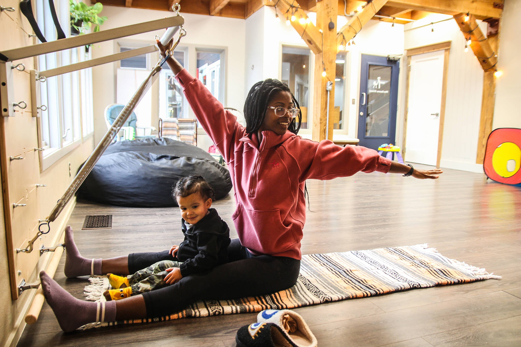 Photo by Luisa Loi
Shelby Novak stretches with the help of a spring board while her son Glenn provides emotional support.
