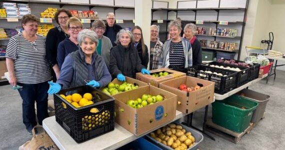 Volunteers at the new Gifts from the Heart food bank, including Coupeville Mayor Molly Hughes (back row, second from left), await their customers on opening day.