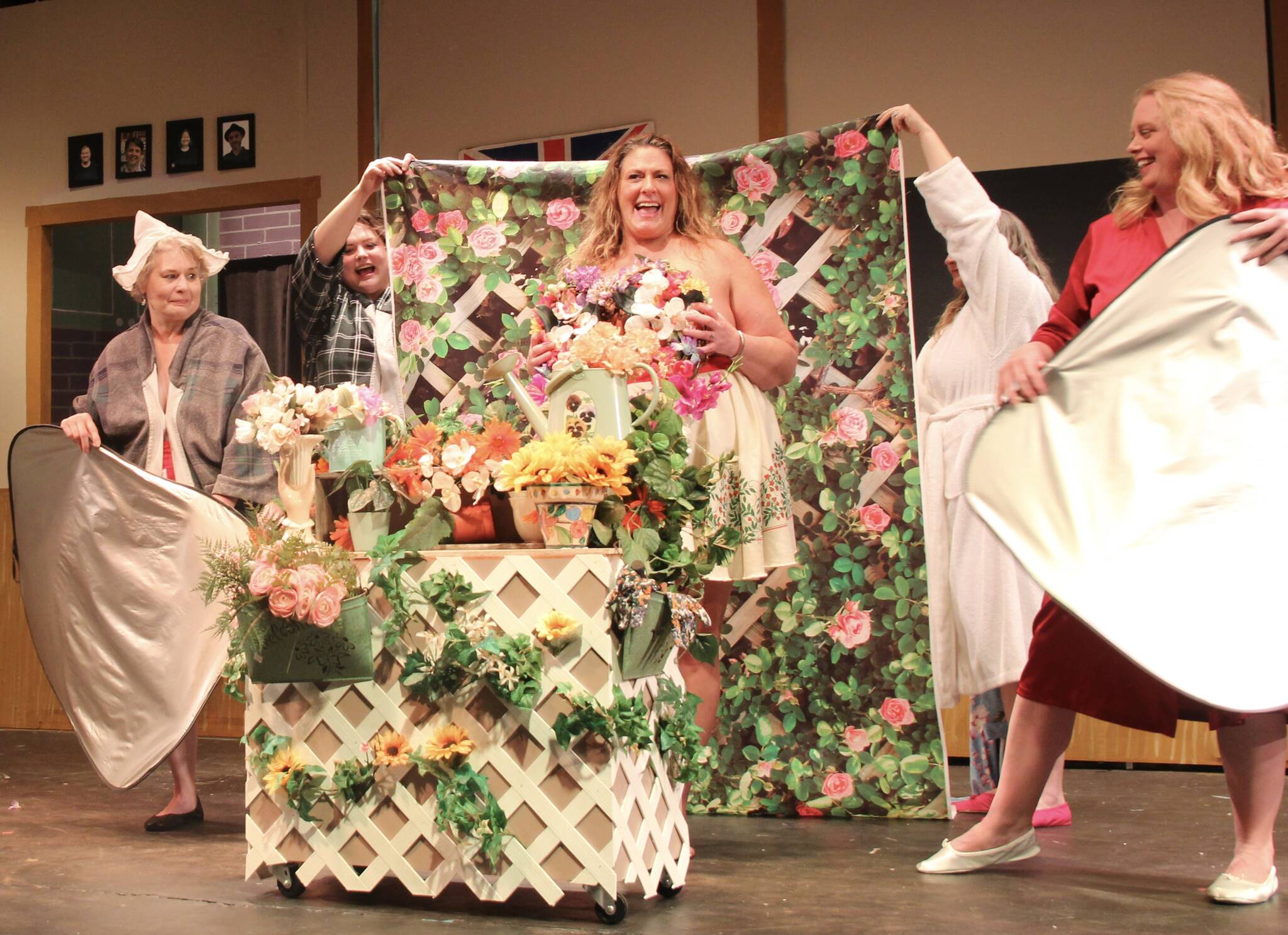 Katie Jones (Chris) poses for her flower calendar girl nude photos. She holds a ring of flowers for modesty.