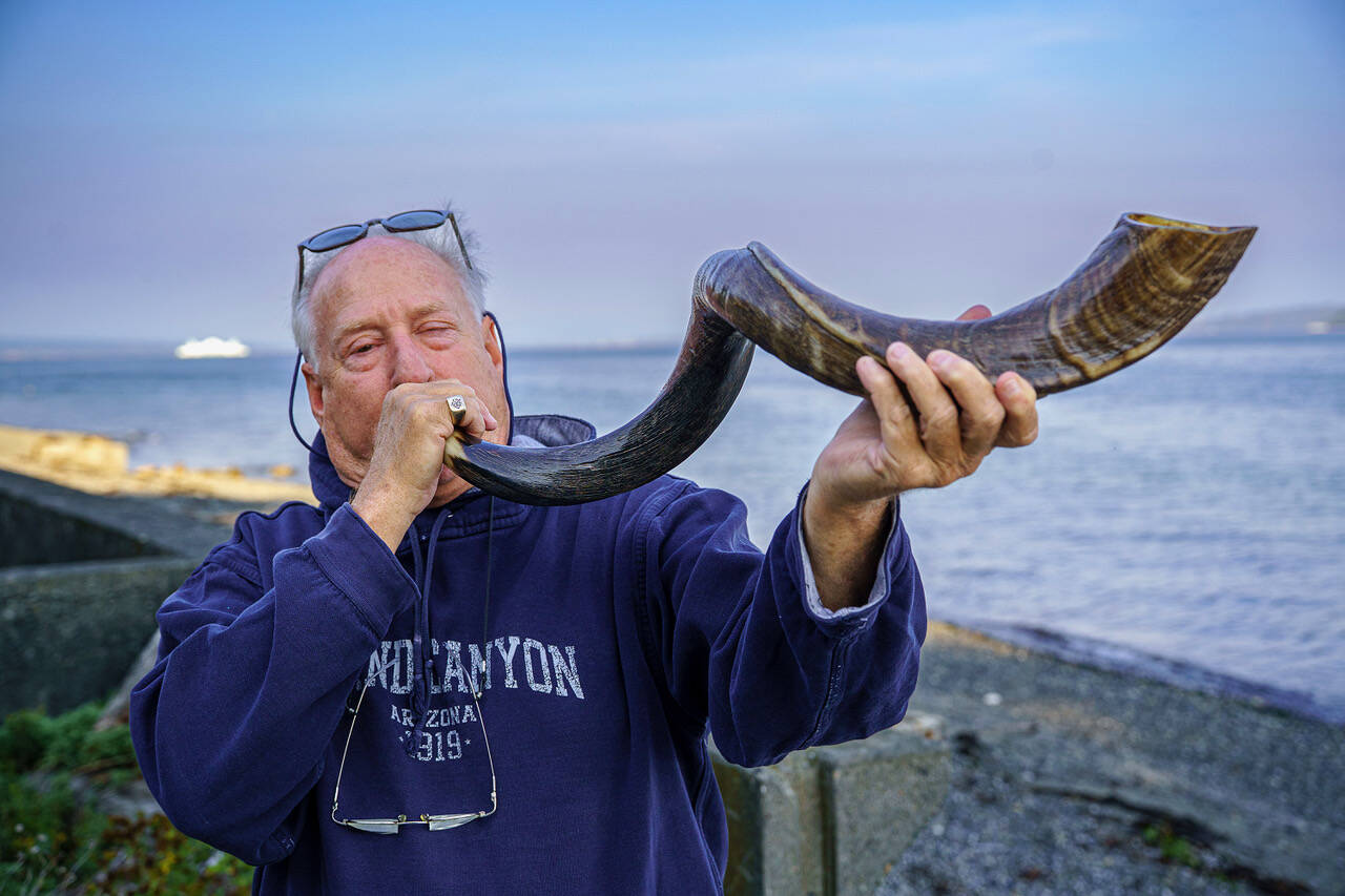 (Photo by David Welton) John Garber blows the shofar, a rams horn, at Glendale Beach.