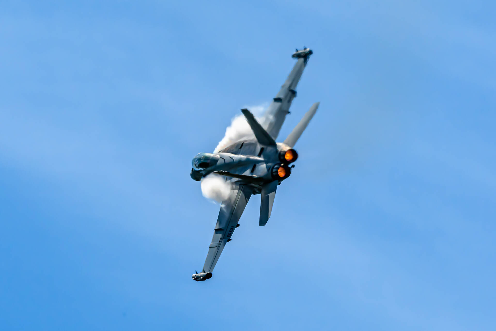Photo by Joe A. Kunzler
Vapor forms of an EA-18G Growler as it streaks through blue skies.