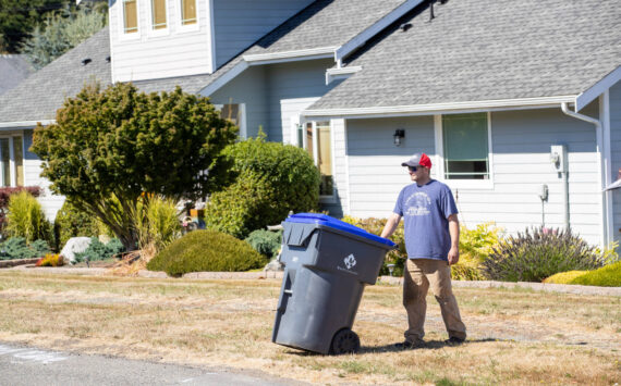 Photo provided by Island Disposal. James Andersen takes an Island Disposal recycling container out to the curb.