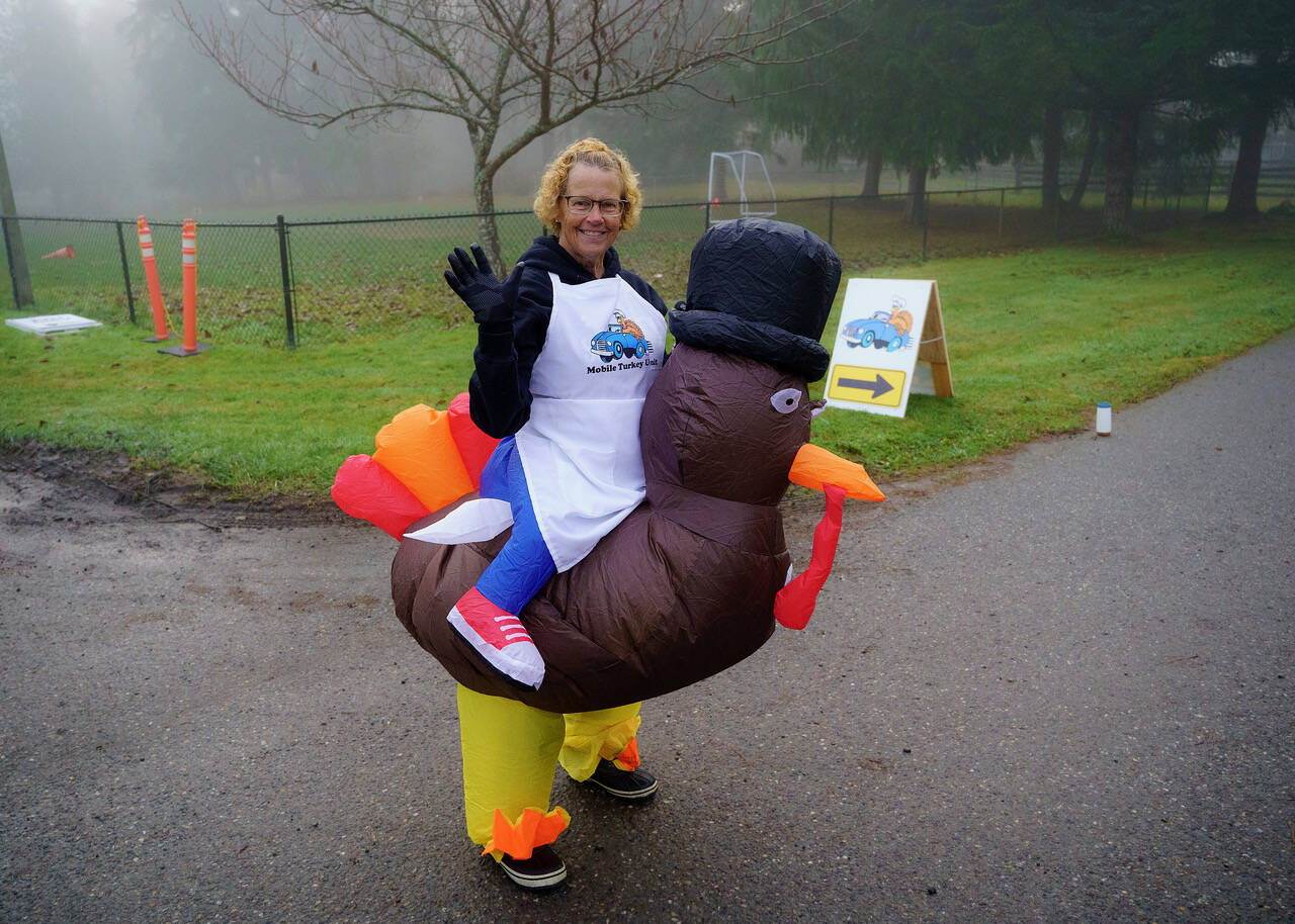 Lana Johnson greets community members in a turkey suit for the Mobile Turkey Unit. (Photo by David Welton)