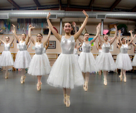Photo by Marina Blatt. Dancers wear white dresses while standing on pointe, with Hannah Brackeen, age 15, in the role of Clara, at the front.