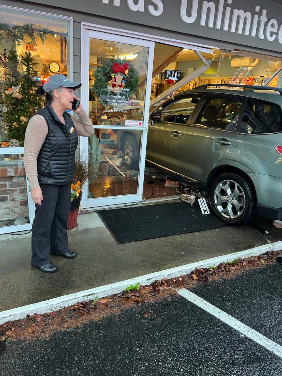 Photo provided by John Norris
A car crashed into Wild Birds Unlimited in Freeland last week. Owner Noel NicFergusson looks on while on the phone.