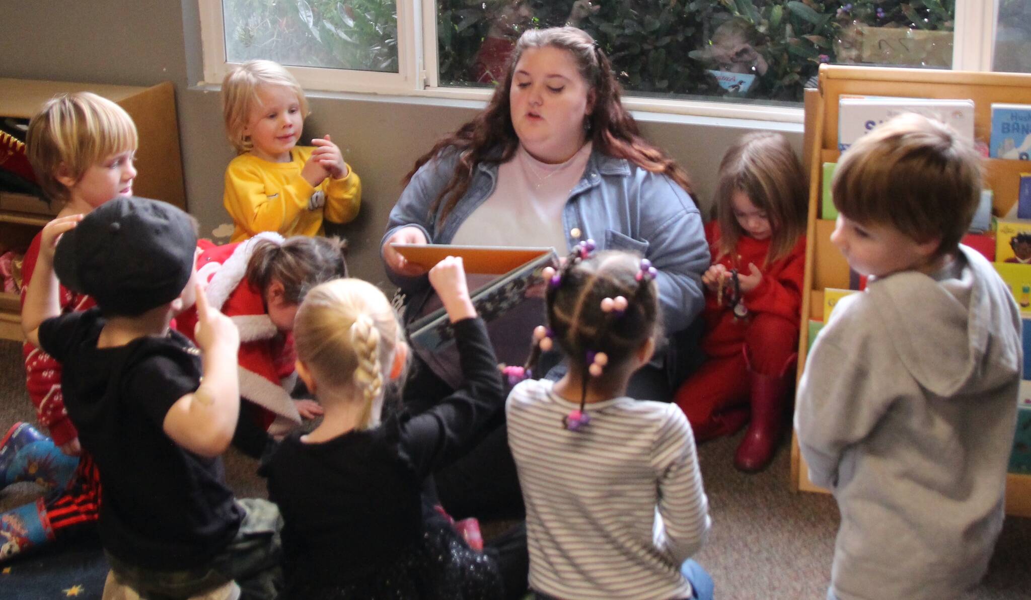 (Photo by Marina Blatt) A teacher reads to her preschool class at the Nurture With Care Kids Academy. The flexible drop-in program offers kid-free time for busy parents who need to make appointments, run errands, take self-care days and attend meetings.