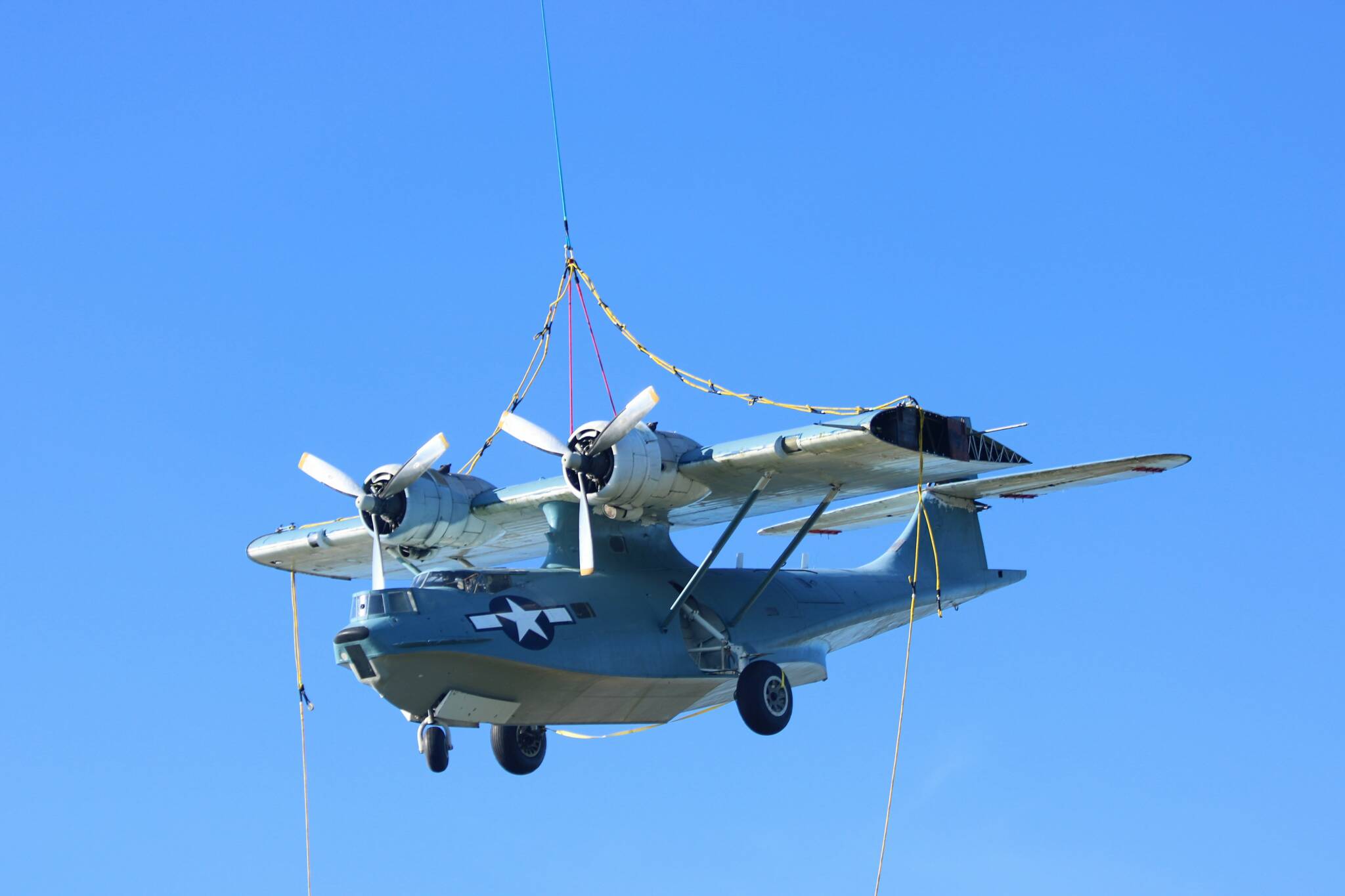 (Photo by Allyson Ballard) The Pacific Northwest Naval Air Museums PBY dangled above downtown Oak Harbor on Wednesday in a uniquely Whidbey spectacle which drew plenty of onlookers.