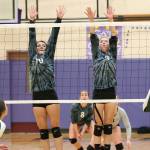 Kristina Tirado, left, and Cami Bristow rise to block for Oak Harbor. (Photo by John Fisken.)