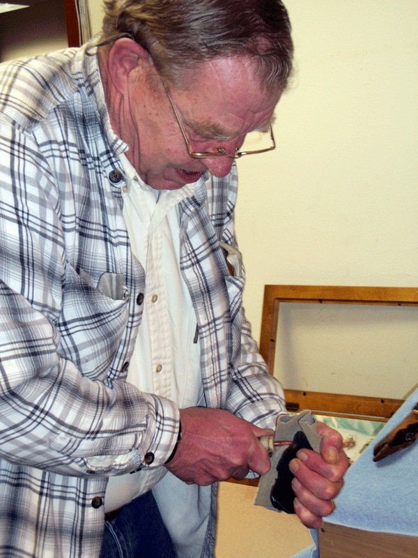 Whidbey Island Gem Club member Chip Batcheller demonstrates how to make an arrowhead out of a piece of obsidian.