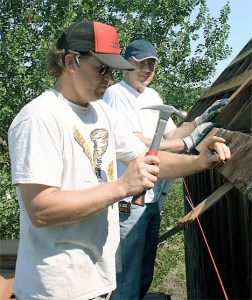 Park Service Preservationist Jason Benson and Coupeville Lions Club member John Purcell install shingles on the historic Boyer Barn.