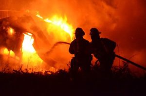 North Whidbey Fire and Rescue Firefighters Chris Turner and Matt VanGiesen fight a fire at a mobile home on Central Whidbey early this morning. No one was injured but the structure was completely destroyed.