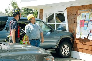 Island County Building Official Andy Griffin looks up at Linds Pharmacy in Coupeville after the driver of a SUV accidentally smashed into the business. He has closed that part of the store until repairs can be made.