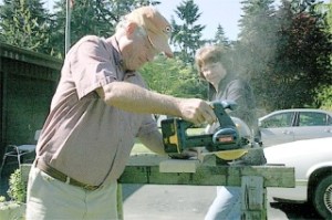 Hearts and Hammers volunteers Janet Wodjenski and Mike Cason cut a board needed to repair a deck at a Greenbank home Saturday.
