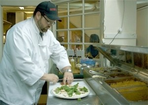 Scott Wotring slices a fresh tomato for a white Tuscan white pizza