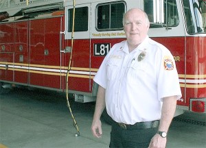 Oak Harbor Fire Chief Ray Merrill stands in front of the department’s 20-year-old ladder truck. He announced a special open house for the 20th anniversary of the fire station will take place on the Fourth of July.