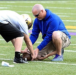 Assistant football coach Mike Fisher teaches the proper grip for a long snap Thursday. The Oak Harbor and Coupeville football teams began practice Wednesday. The other prep sports begin Monday.
