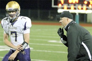 Offensive coordinator Mike Fisher relays a play to Wildcat quarterback Ian Kolste.