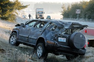 Washington State Patrol Trooper Scott Wernecke walks toward the scene of a rollover accident on Highway 20 just north of Coupeville.