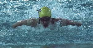Emily Huffer swims to a school record in the 100 butterfly at the district meet Saturday.