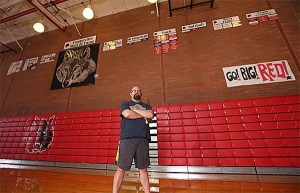David Svien stands before the recently mounted championship tiles.
