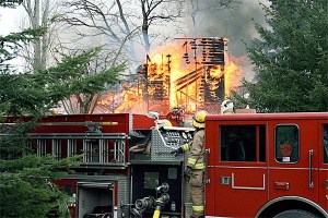 Firefighters from North Whidbey Fire and Rescue operate a truck while a farmhouse on Ault Field Road burns to the ground March 12 as part of a training exercise. The home was owned by Westgate Home and RV.