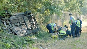 Emergency personnel prepare to whisk away a woman to the hospital after she rolled her car Monday morning on Highway 20 south of Coupeville.