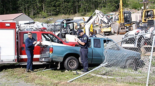Emergency response personnel take notes at the scene of a collision on Oak Harbor Road Friday morning. An emergency vehicle from North Whidbey Fire and Rescue collided with a pickup.
