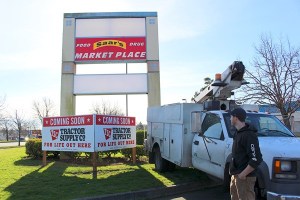 Workers install a Tractor Supply Co. sign just off State Highway 20 near the old Kmart.