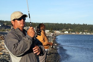 Anglers bundle up as temperatures drop and the wind picks up at Driftwood Park at the Keystone spit in Coupeville Thursday night. Fishing for pink salmon was slow from this popular spot Thursday night but picked up again Friday morning. The pink salmon return to Puget Sound every other year in large numbers.
