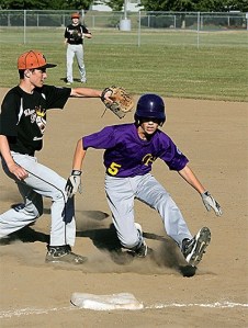 Austin Boesch gets out of a rundown by slipping under the tag of Whatcom's first baseman Thursday.