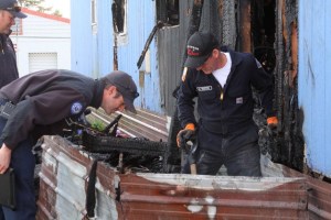 Mike Buxton of the Oak Harbor Fire Department investigates a fire at Terry Mobile Park in Coupeville Thursday