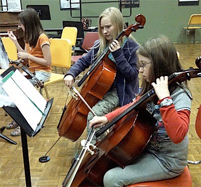 Whidbey Island Youth Orchestra cellists Chloe Edwards and Skye Kelly rehearse.