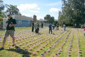Volunteers help plant hundreds of flags on the lawns of Burley Funeral Chapel in honor of those who died on Sept. 11
