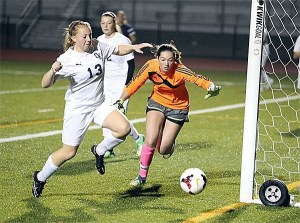 Oak Harbor's Suzanne Kaltenbach (13) can't quite slip a goal past Meadowdale keeper Alivia Wynar.