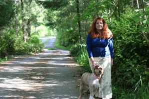 North Whidbey resident Becky Moss stands at the edge of property on the private road leading to her home. She says the road and trees would be decimated if a cell tower is raised in the woods behind her. Several trees are already marked with orange dots.