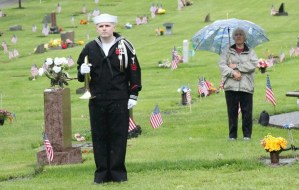 A bugler stands in the rain during the Memorial Day ceremony at Maple Leaf cemetery.