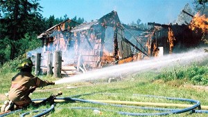 North Whidbey Fire and Rescue firefighter Mike Myrum ensures a training fire Saturday doesn’t spread to nearby trees and bushes.