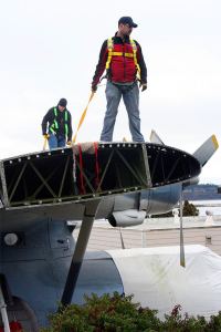 Workers get ready to move the PBY Catalina aircraft.