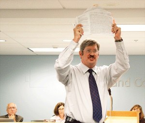 Coupeville resident Kenneth Wolf gives a fiery speech Monday in opposition to a proposed clean water utility district. He held up a petition against the Island County septic program