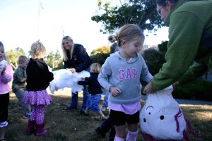 Students and teacher Tami Aparicio rip up pillow stuffing while Lyla Stuurmans stuffs it into their scarecrow’s head.
