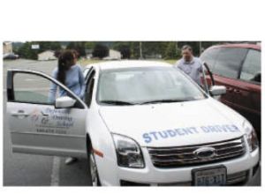GS Defensive Driving School owners Heather Scott and Michael Groves board their instruction car.