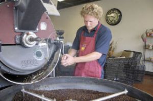 Roast Master Mike Donohoe finishes a batch of the Vienna roast after several minutes of careful watch. The beans will be packaged for Buzz Bomb