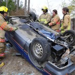 Photo by Michael Watkins/Whidbey News-Times                                Volunteer firefighters with North Whidbey Fire and Rescue station 25 work together to secure an overturned vehicle during a simulated rescue Saturday in Oak Harbor.