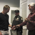 Tony Hartman (right) gives Eric Vasilyev (left) the belt that was used as a makeshift tourniquet to slow blood flow to his injured arm.
