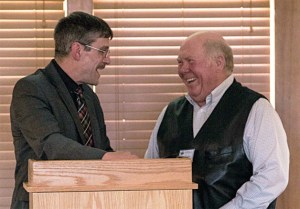 Island County Commissioner Rick Hannold presents a Community Health Hero award to retired pastor David Lura.