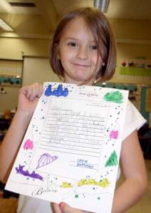 Summer Aplass holds up her letter to Santa